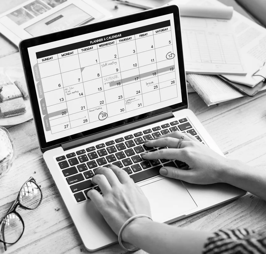 Pessoa organizando a agenda da campanha num calendário aberto no notebook
